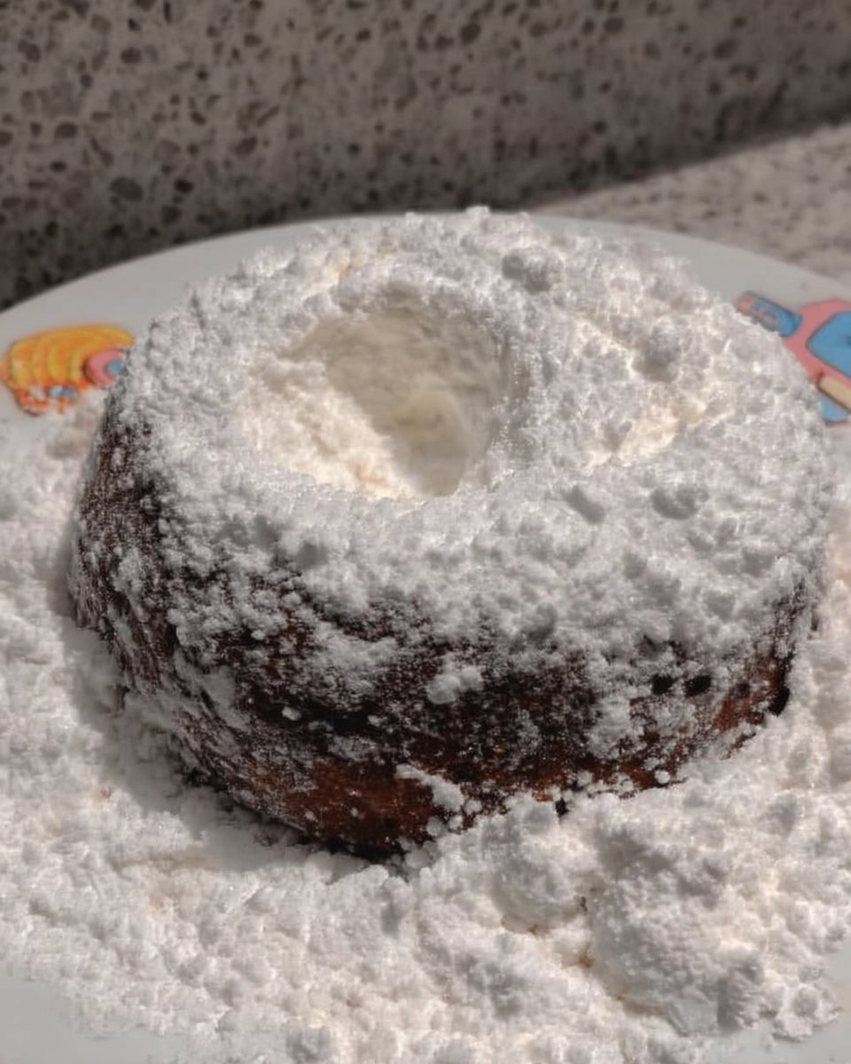 Warm cookies being coated in powdered sugar for moisture retention