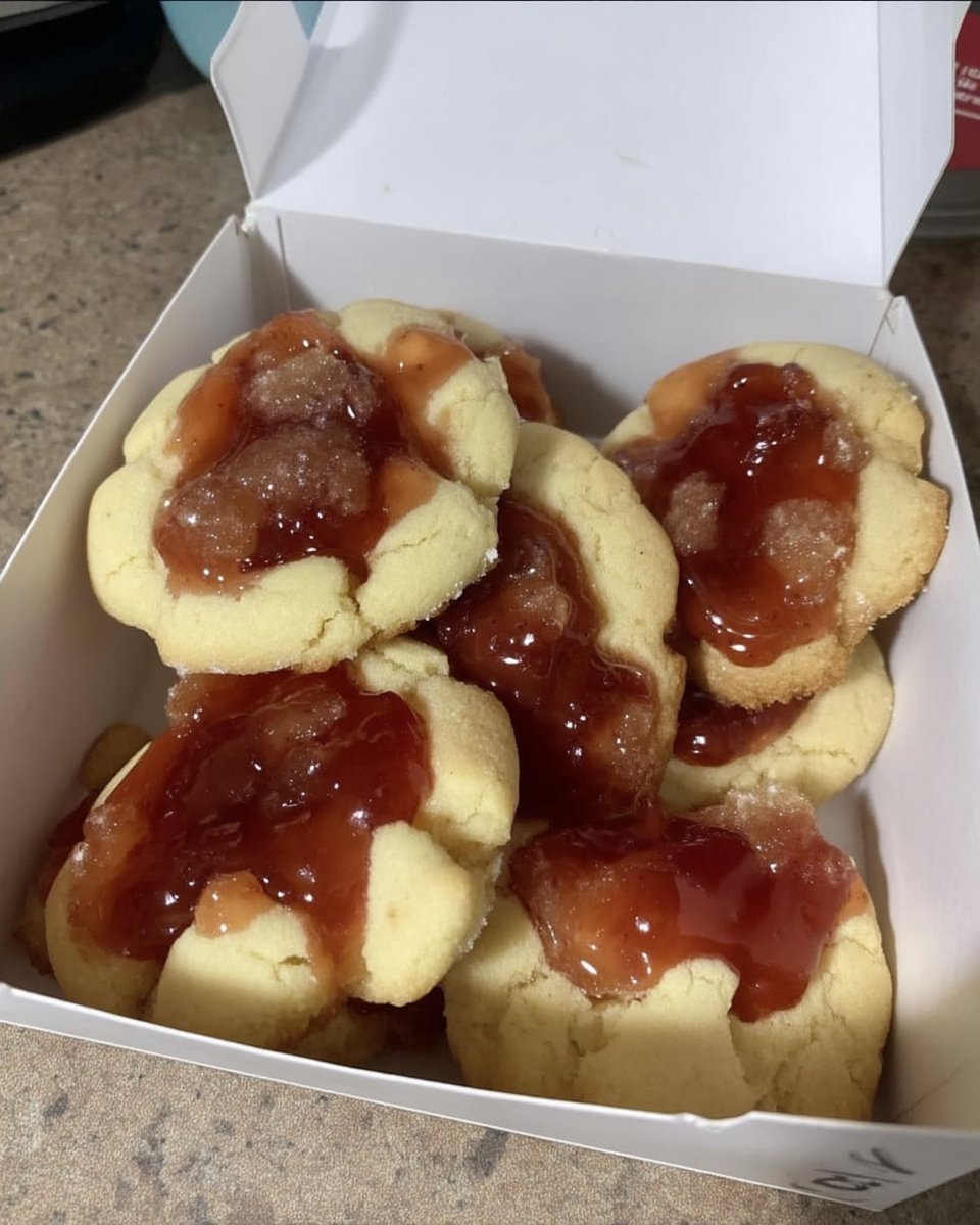Baked thumbprint cookies filled with jam on a vintage platter
