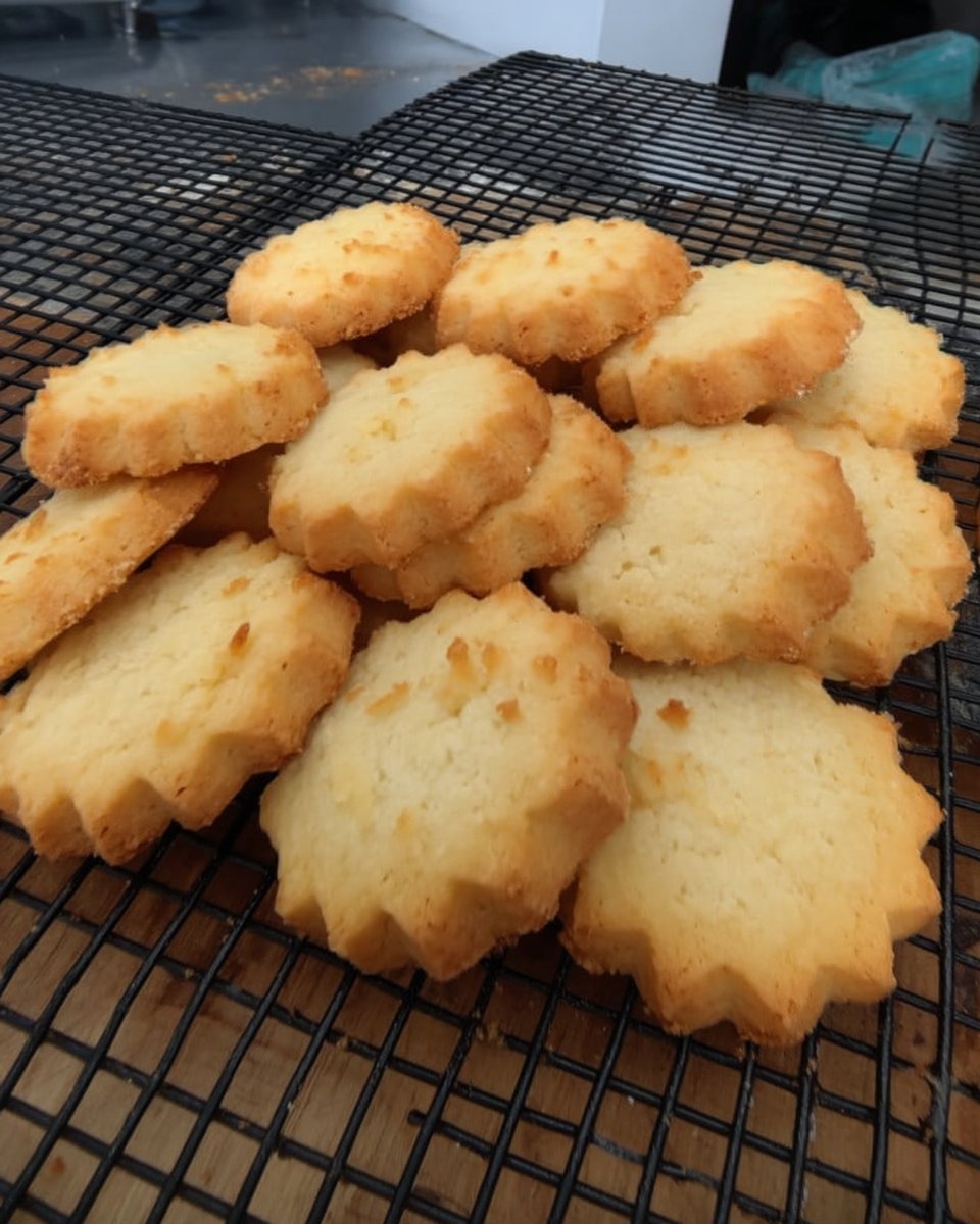 Golden Heidesand cookies stacked next to a vintage glass milk bottle