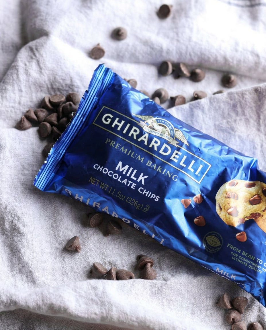 Raw cookie dough portions with jagged tops arranged on a parchment-lined baking sheet.