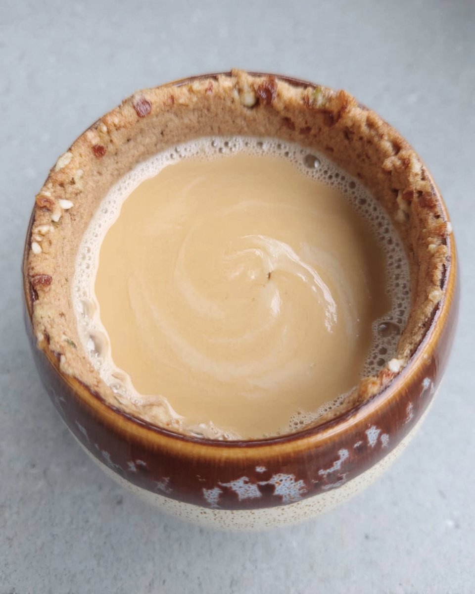 A close up of cookie dough being dropped onto a parchment lined baking sheet.