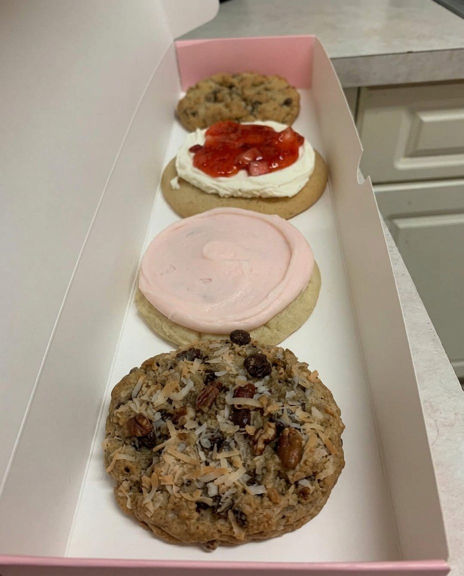 Large chocolate chip cookies piled high inside an old-fashioned glass cookie jar