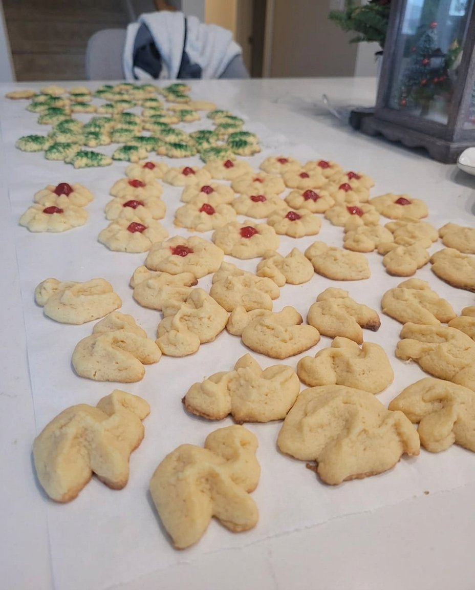 A platter of decorated vanilla spritz cookies with sprinkles and chocolate drizzle