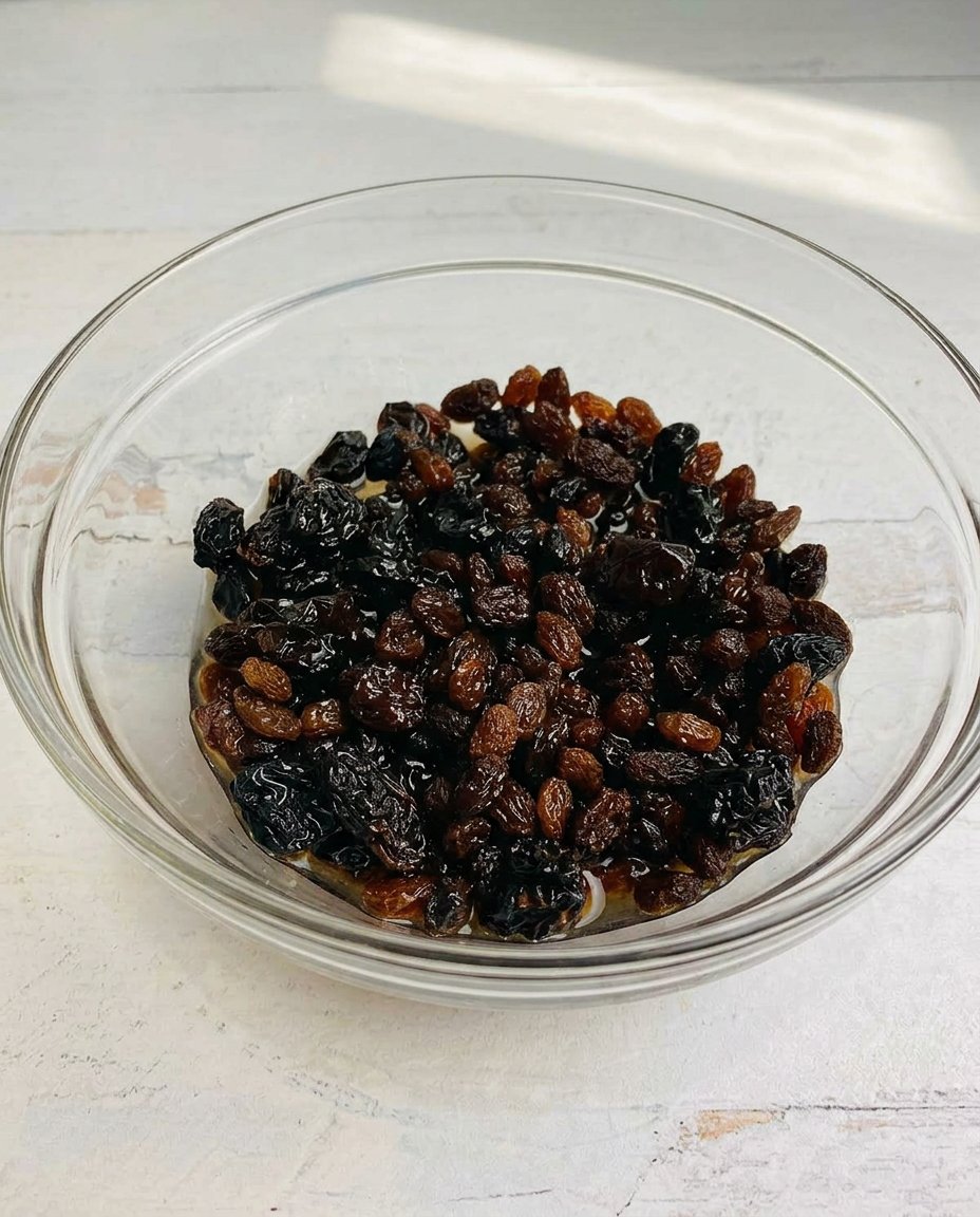 Close up of a hand scooping cookie dough onto a baking sheet with parchment paper.