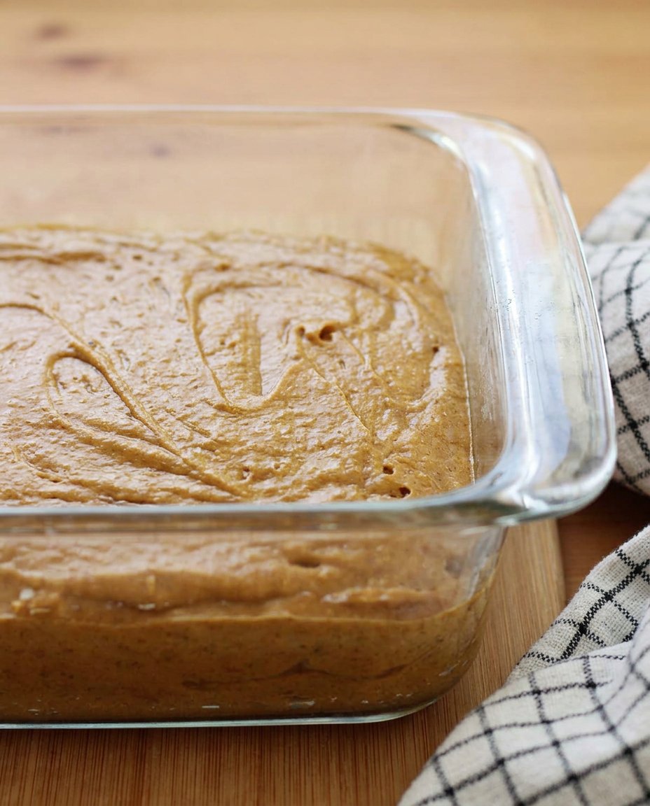 Slicing a square of moist gingerbread cake onto a plate.