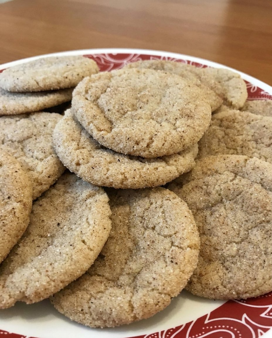 A pile of Chai Snickerdoodles with a crinkly spice-coated surface on a white plate.