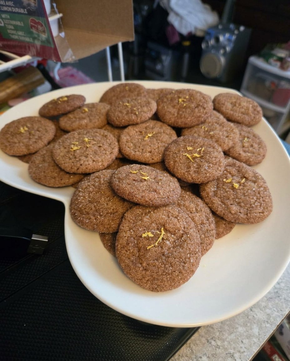 A stack of crisp lemon ginger snap sandwich cookies on a cooling rack.