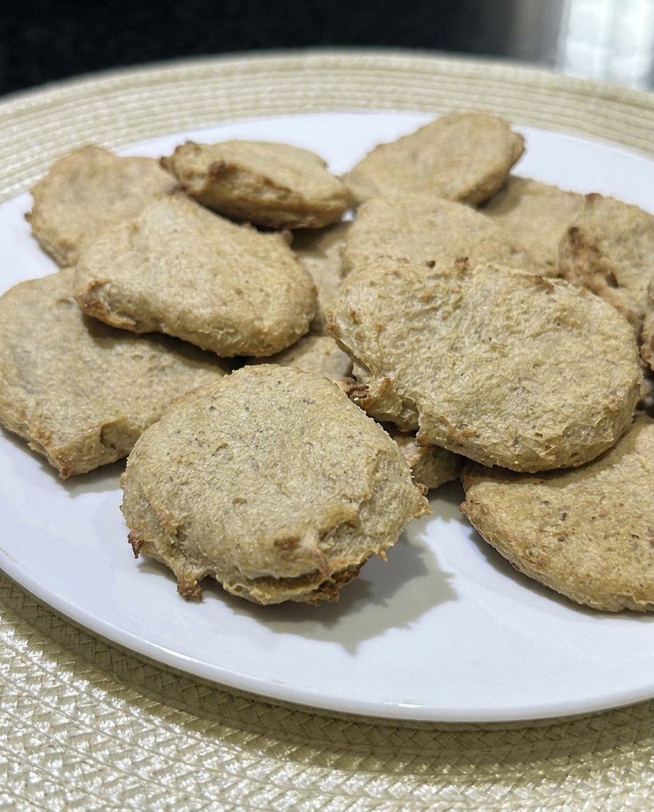 A stack of soft peanut butter cookies next to a cold glass of milk.