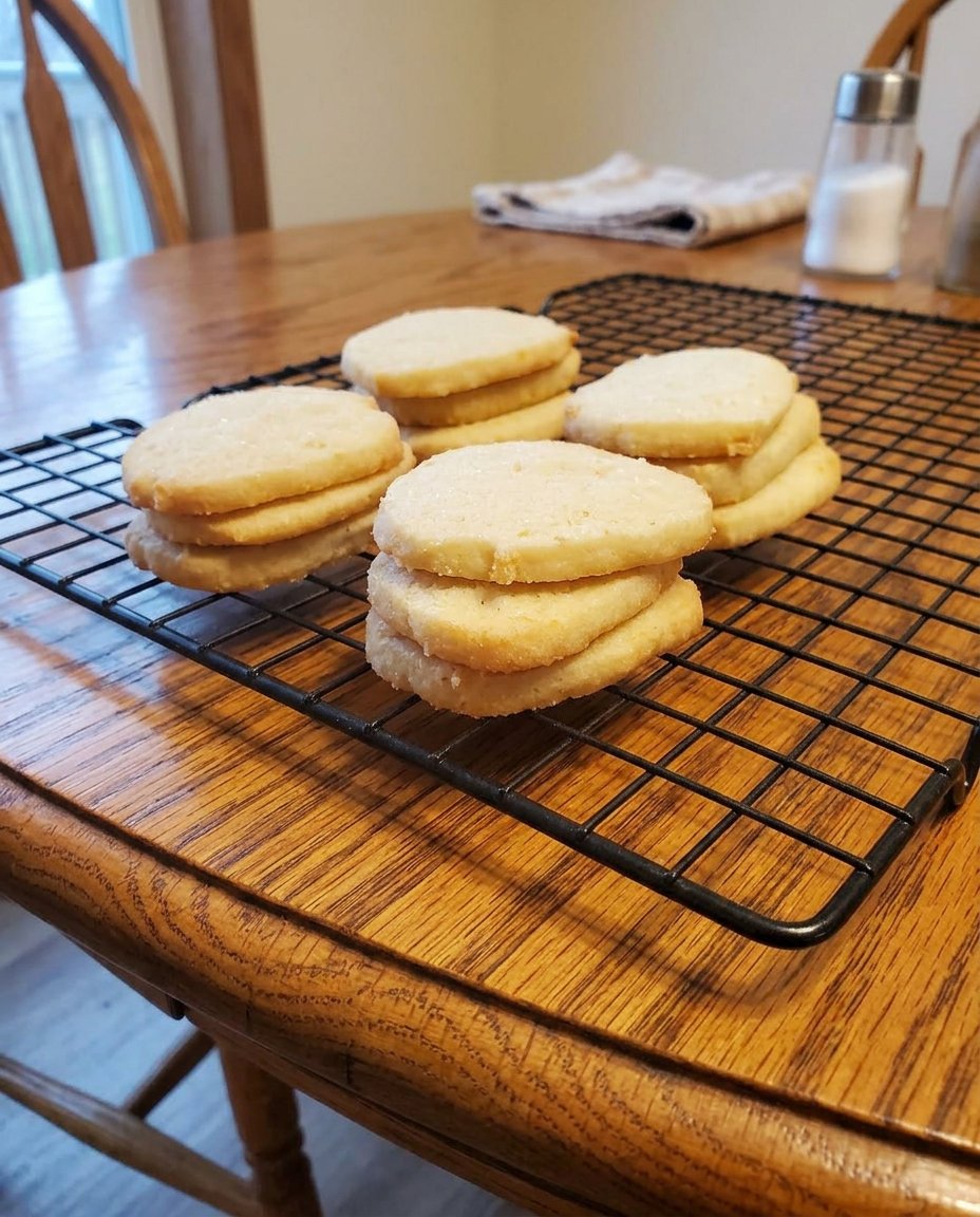 Thinly sliced icebox cookies with almonds on a cooling rack